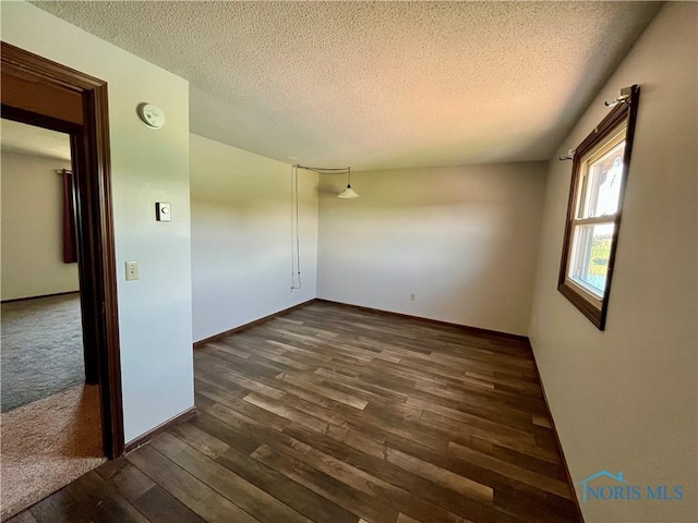17988 Rd 156, Paulding, OH 45879 - spare room with dark wood-style flooring, a textured ceiling, and a smoke detector
