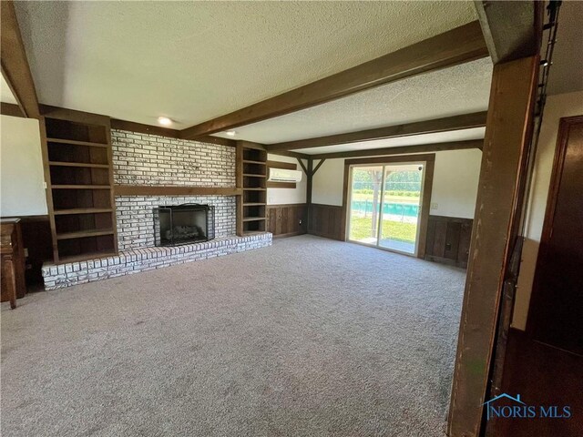 17988 Rd 156, Paulding, OH 45879 - unfurnished living room featuring a textured ceiling, beam ceiling, a wainscoted wall, built in features, and a wall unit AC