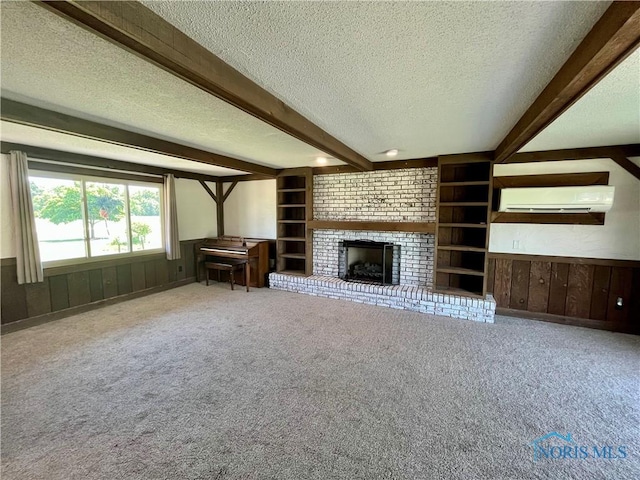 17988 Rd 156, Paulding, OH 45879 - unfurnished living room with a textured ceiling, a wall mounted air conditioner, beam ceiling, a brick fireplace, and carpet flooring