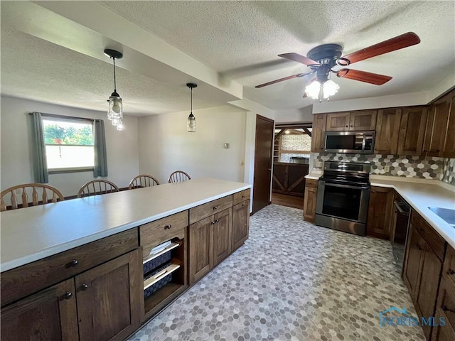 17988 Rd 156, Paulding, OH 45879 - kitchen featuring stainless steel appliances, a textured ceiling, pendant lighting, backsplash, and light countertops