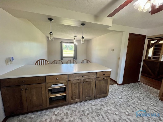 17988 Rd 156, Paulding, OH 45879 - kitchen featuring ceiling fan, a breakfast bar, decorative light fixtures, a textured ceiling, and a peninsula