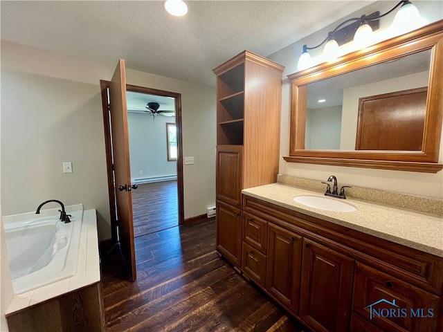 17988 Rd 156, Paulding, OH 45879 - full bathroom featuring vanity, a baseboard heating unit, a ceiling fan, wood finished floors, and a textured ceiling