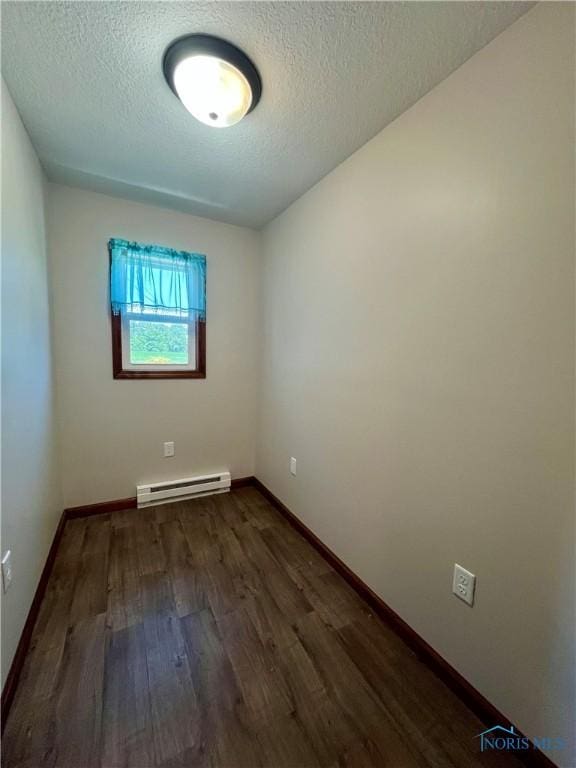 17988 Rd 156, Paulding, OH 45879 - empty room featuring a baseboard radiator, dark wood-type flooring, and a textured ceiling