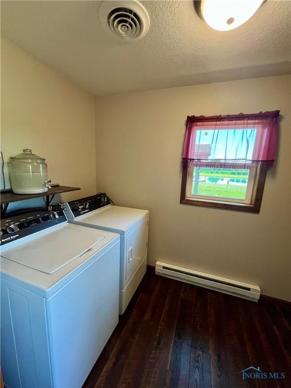17988 Rd 156, Paulding, OH 45879 - laundry room with a baseboard heating unit, dark wood finished floors, separate washer and dryer, and a textured ceiling