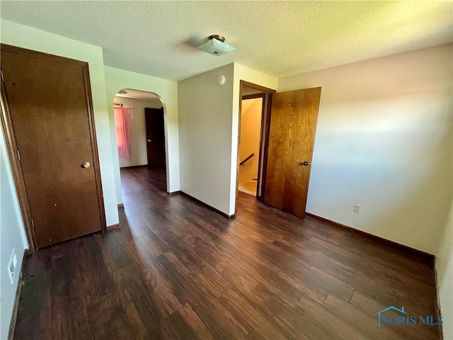 17988 Rd 156, Paulding, OH 45879 - spare room with arched walkways, dark wood-style floors, and a textured ceiling