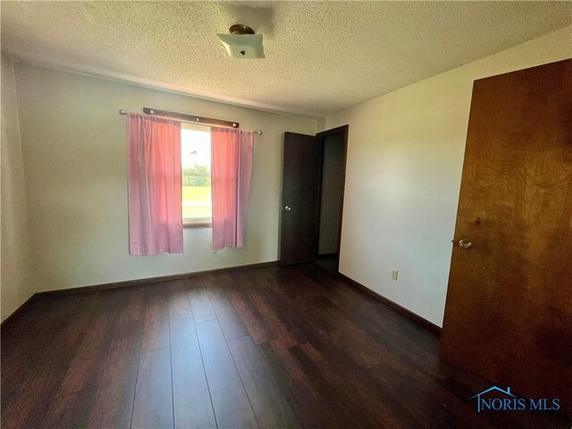 17988 Rd 156, Paulding, OH 45879 - spare room featuring dark wood finished floors and a textured ceiling