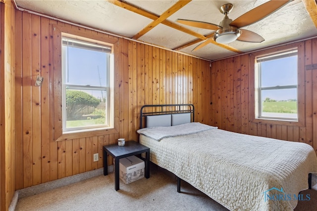 18735 Wall St, Tontogany, OH 43565 - carpeted bedroom featuring multiple windows, wooden walls, and ceiling fan