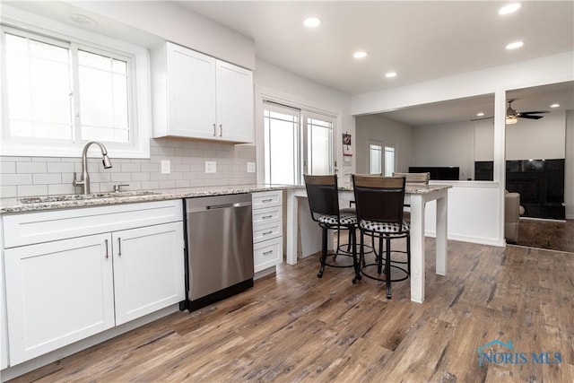6842 Shieldwood Rd, Toledo, OH 43617 - kitchen featuring dishwasher, recessed lighting, wood finished floors, white cabinets, and backsplash