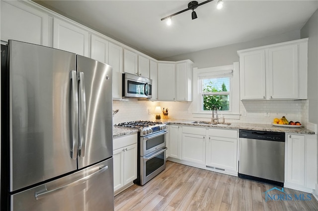 233 E 5th St, Perrysburg, OH 43551 - kitchen featuring appliances with stainless steel finishes, white cabinets, backsplash, and light stone countertops