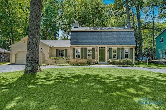 5941 Indian Trl, Sylvania, OH 43560 - dutch colonial featuring a chimney, an attached garage, driveway, and brick siding