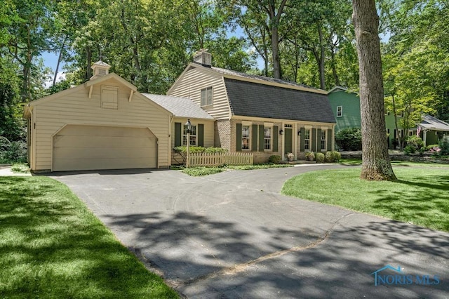 5941 Indian Trl, Sylvania, OH 43560 - dutch colonial featuring asphalt driveway, a garage, a gambrel roof, a chimney, and a shingled roof