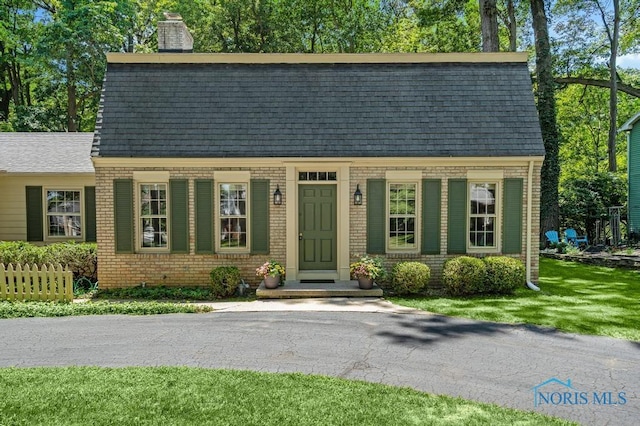 5941 Indian Trl, Sylvania, OH 43560 - view of front of home featuring a chimney, brick siding, and roof with shingles
