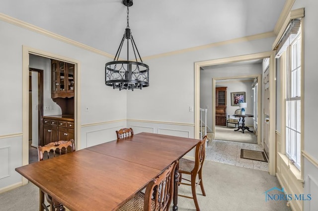 5941 Indian Trl, Sylvania, OH 43560 - dining space with a chandelier, ornamental molding, light carpet, wainscoting, and plenty of natural light