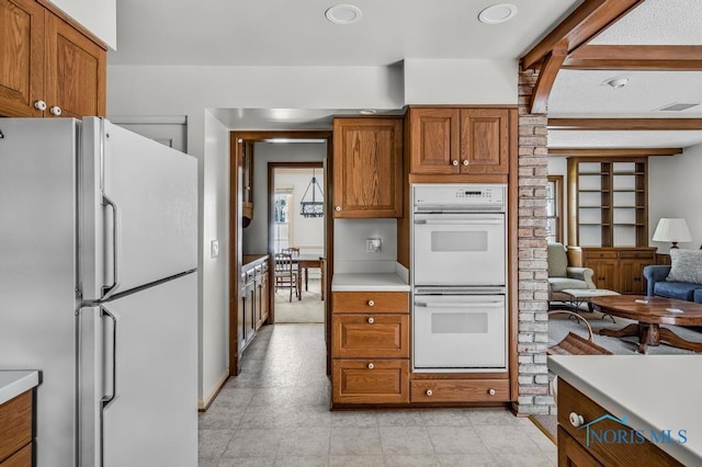 5941 Indian Trl, Sylvania, OH 43560 - kitchen featuring white appliances, light countertops, brown cabinetry, and open floor plan