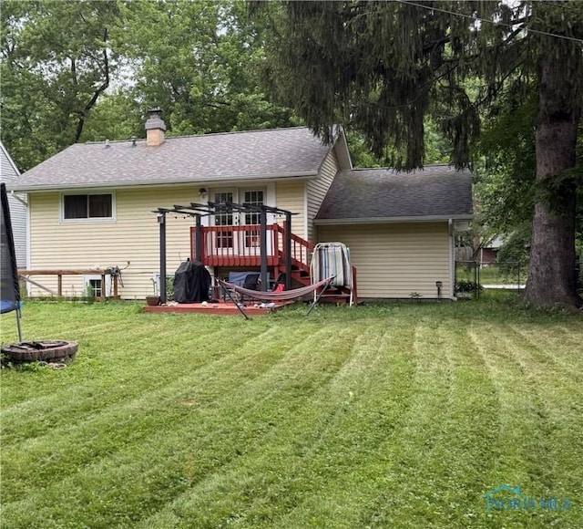 813 Maple Ln, Waterville, OH 43566 - back of property featuring roof with shingles, a chimney, a trampoline, and a wooden deck