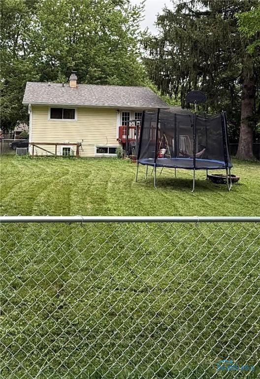813 Maple Ln, Waterville, OH 43566 - back of property with a trampoline, a fenced backyard, and a chimney