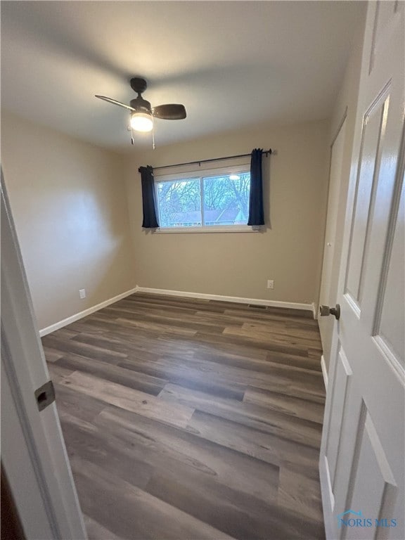 813 Maple Ln, Waterville, OH 43566 - unfurnished bedroom with dark wood finished floors and ceiling fan