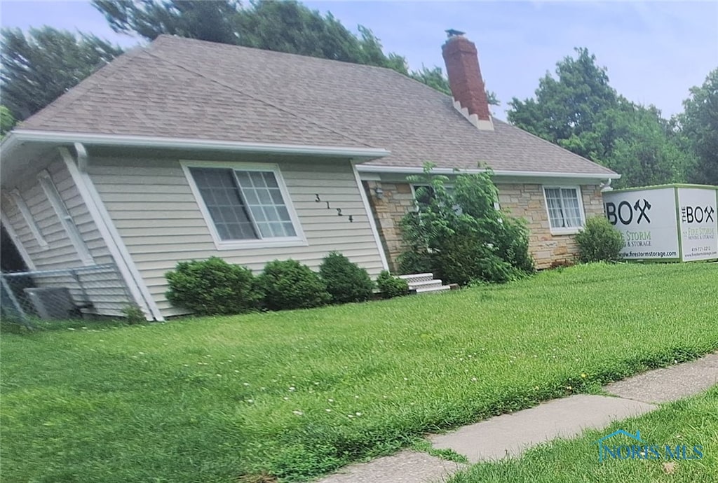 3124 Copland Blvd, Toledo, OH 43614 - view of front of property with a front lawn, a chimney, roof with shingles, and stone siding