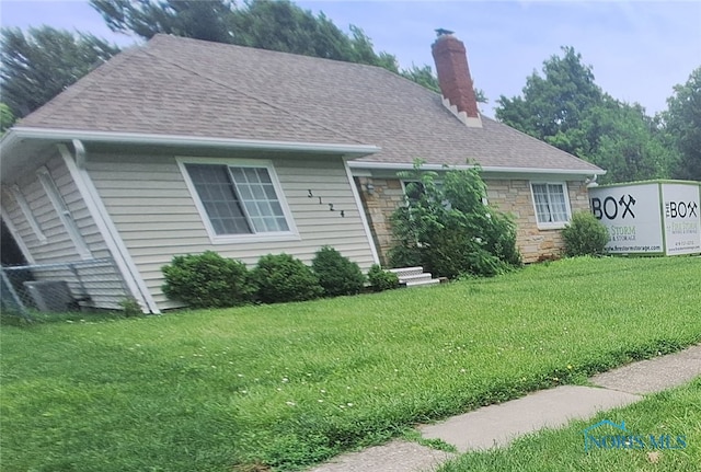 3124 Copland Blvd, Toledo, OH 43614 - view of front of property with a front lawn, a chimney, roof with shingles, and stone siding