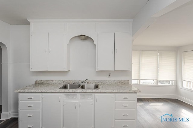 708 Spencer St, Toledo, OH 43609 - kitchen featuring arched walkways, white cabinetry, and dark wood-style floors