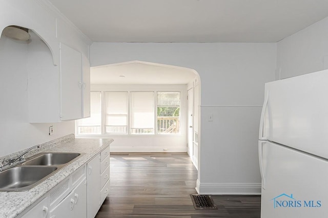 708 Spencer St, Toledo, OH 43609 - kitchen featuring freestanding refrigerator, white cabinetry, dark wood-type flooring, and light countertops
