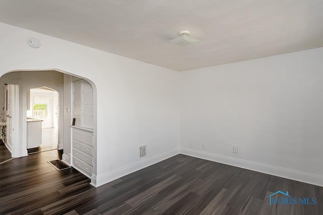 708 Spencer St, Toledo, OH 43609 - spare room with dark wood finished floors and arched walkways