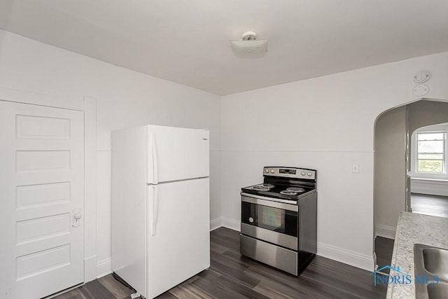 708 Spencer St, Toledo, OH 43609 - kitchen with freestanding refrigerator, stainless steel electric range oven, arched walkways, and dark wood-style flooring