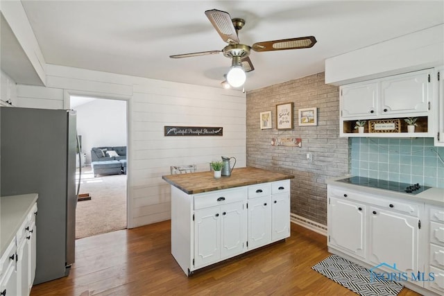 12982 State Route 34, Bryan, OH 43506 - kitchen featuring freestanding refrigerator, black electric stovetop, a ceiling fan, white cabinets, and dark wood-style floors
