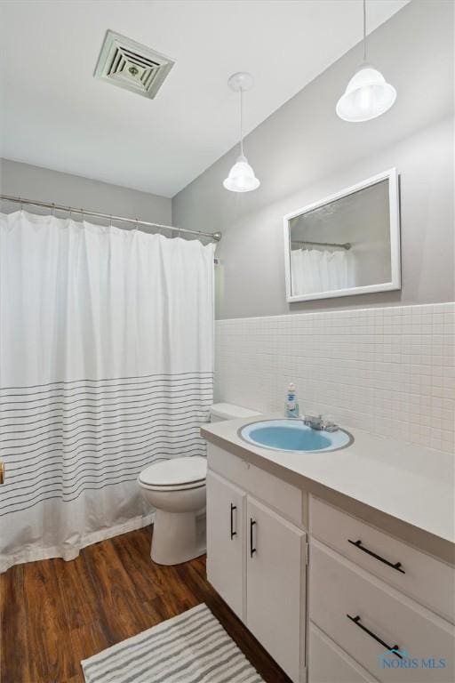 12982 State Route 34, Bryan, OH 43506 - bathroom featuring vanity, wood finished floors, tile walls, and curtained shower