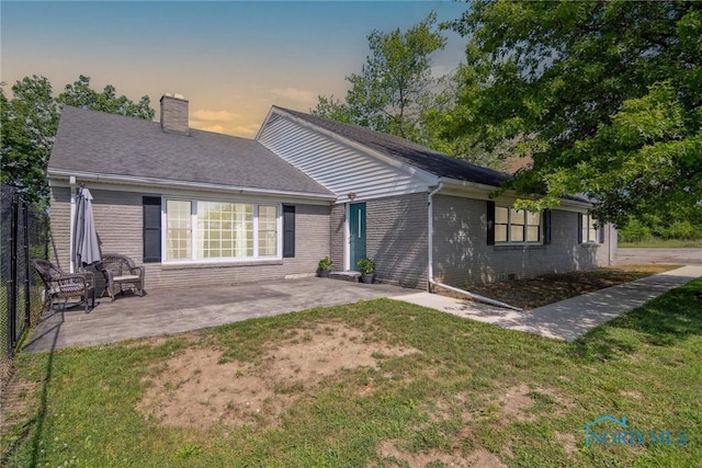 12982 State Route 34, Bryan, OH 43506 - back of property featuring brick siding, a chimney, a patio, and a lawn