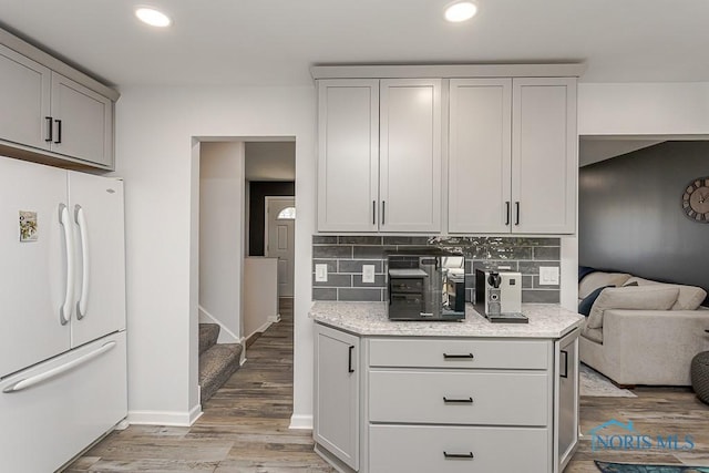 5157 Brinthaven Dr, Sylvania, OH 43560 - kitchen featuring freestanding refrigerator, light wood finished floors, decorative backsplash, gray cabinetry, and light stone counters