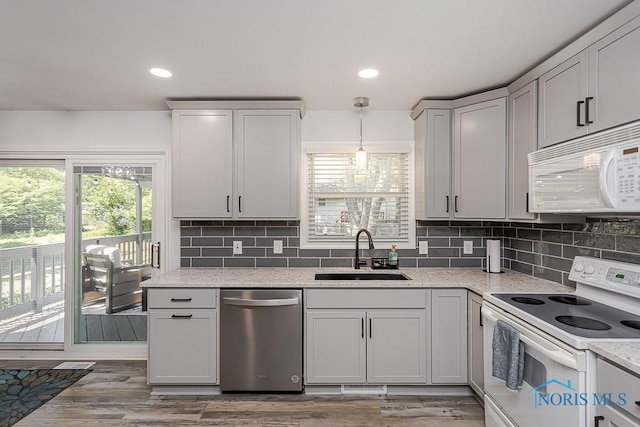 5157 Brinthaven Dr, Sylvania, OH 43560 - kitchen with white appliances, plenty of natural light, tasteful backsplash, wood finished floors, and recessed lighting