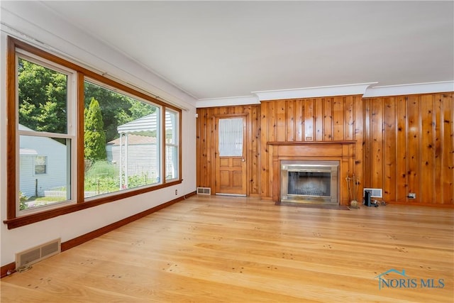 3328 Island Ave, Toledo, OH 43614 - unfurnished living room featuring crown molding, a glass covered fireplace, wooden walls, and wood finished floors