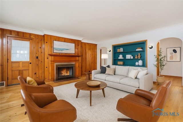 3328 Island Ave, Toledo, OH 43614 - living area with arched walkways, ornamental molding, light wood-style floors, a fireplace with flush hearth, and built in features