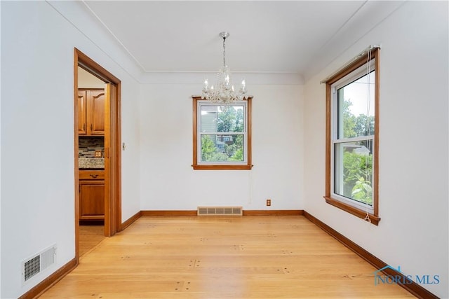 3328 Island Ave, Toledo, OH 43614 - empty room featuring a chandelier, plenty of natural light, and light wood-type flooring