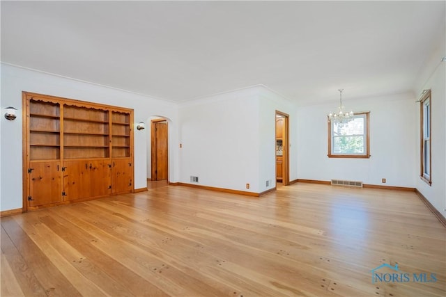 3328 Island Ave, Toledo, OH 43614 - unfurnished living room featuring a chandelier, light wood-style floors, and arched walkways