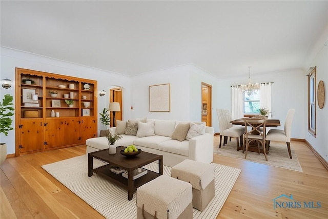 3328 Island Ave, Toledo, OH 43614 - living room with a chandelier, light wood-style floors, and arched walkways