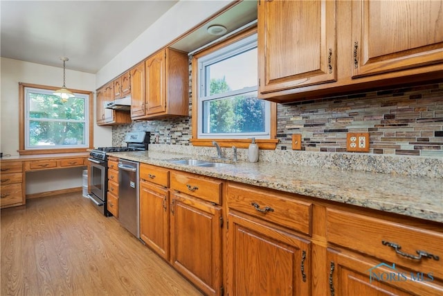 3328 Island Ave, Toledo, OH 43614 - kitchen featuring appliances with stainless steel finishes, light wood-style floors, brown cabinetry, and light stone countertops