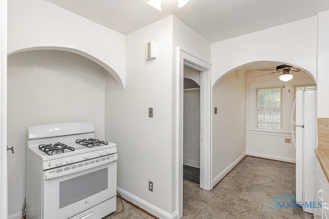 2529 Greenbriar Rd, Toledo, OH 43607 - kitchen featuring white appliances, arched walkways, a ceiling fan, and light stone finish flooring