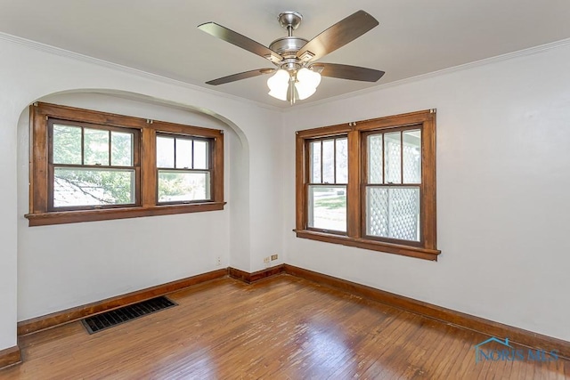 2529 Greenbriar Rd, Toledo, OH 43607 - unfurnished room featuring hardwood / wood-style flooring, plenty of natural light, ornamental molding, ceiling fan, and arched walkways