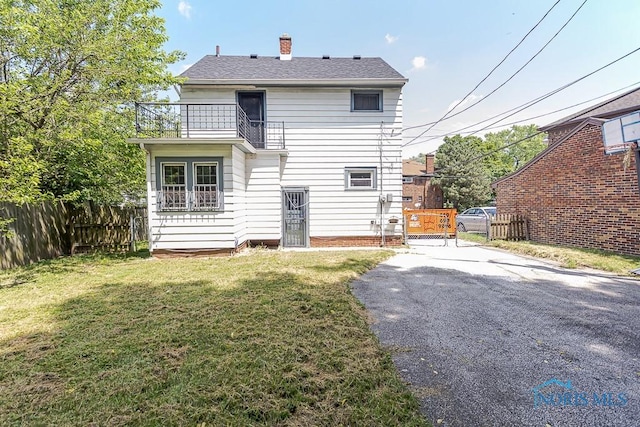 2529 Greenbriar Rd, Toledo, OH 43607 - rear view of house featuring a balcony, driveway, and a chimney