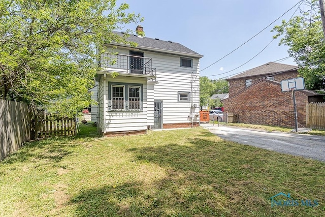 2529 Greenbriar Rd, Toledo, OH 43607 - rear view of house featuring a balcony, asphalt driveway, and a chimney