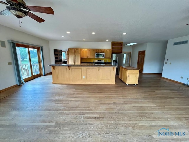 13362 Road 27C, Antwerp, OH 45813 - kitchen featuring appliances with stainless steel finishes, a center island, light wood-style flooring, dark countertops, and recessed lighting