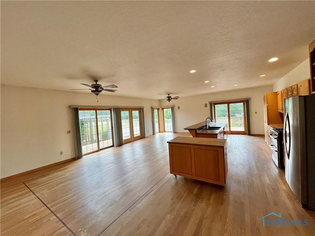 13362 Road 27C, Antwerp, OH 45813 - kitchen featuring freestanding refrigerator, open floor plan, ceiling fan, a textured ceiling, and a kitchen island with sink