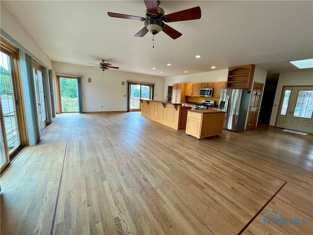 13362 Road 27C, Antwerp, OH 45813 - kitchen featuring appliances with stainless steel finishes, open floor plan, light wood-style floors, open shelves, and a kitchen bar