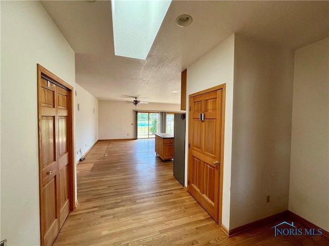 13362 Road 27C, Antwerp, OH 45813 - hallway featuring light wood-type flooring, a skylight, and a textured ceiling
