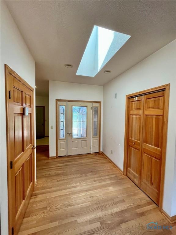 13362 Road 27C, Antwerp, OH 45813 - foyer featuring a skylight, light wood-type flooring, a textured ceiling, and lofted ceiling