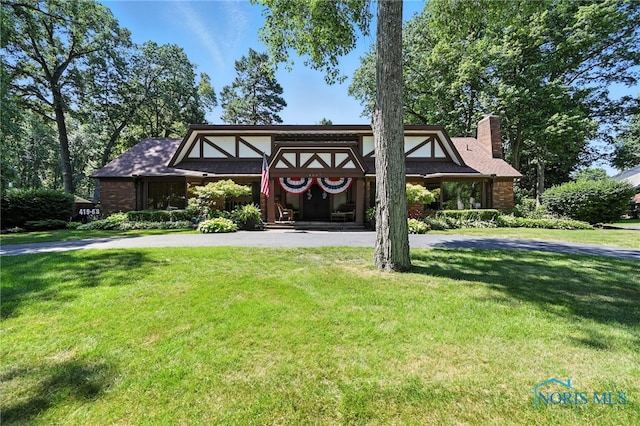 4567 Torquay Ave, Toledo, OH 43615 - view of front of property featuring a chimney, a front lawn, and curved driveway