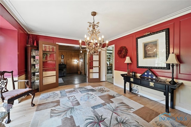 4567 Torquay Ave, Toledo, OH 43615 - entryway featuring wood finished floors, a chandelier, a decorative wall, and ornamental molding