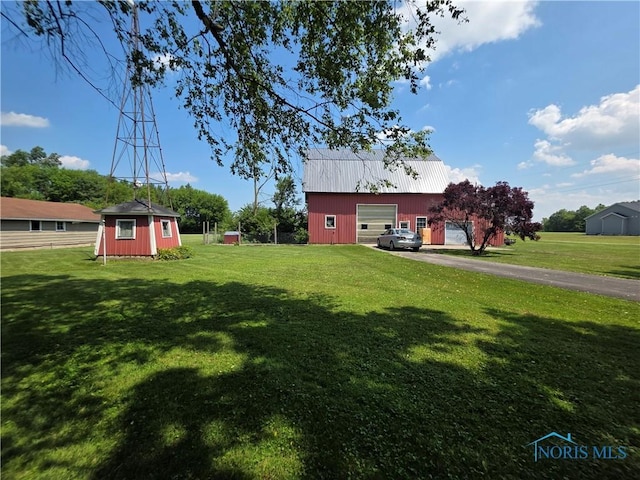 12406 Cross Creek Rd, Bowling Green, OH 43402 - view of grassy yard with an outbuilding, a garage, and driveway